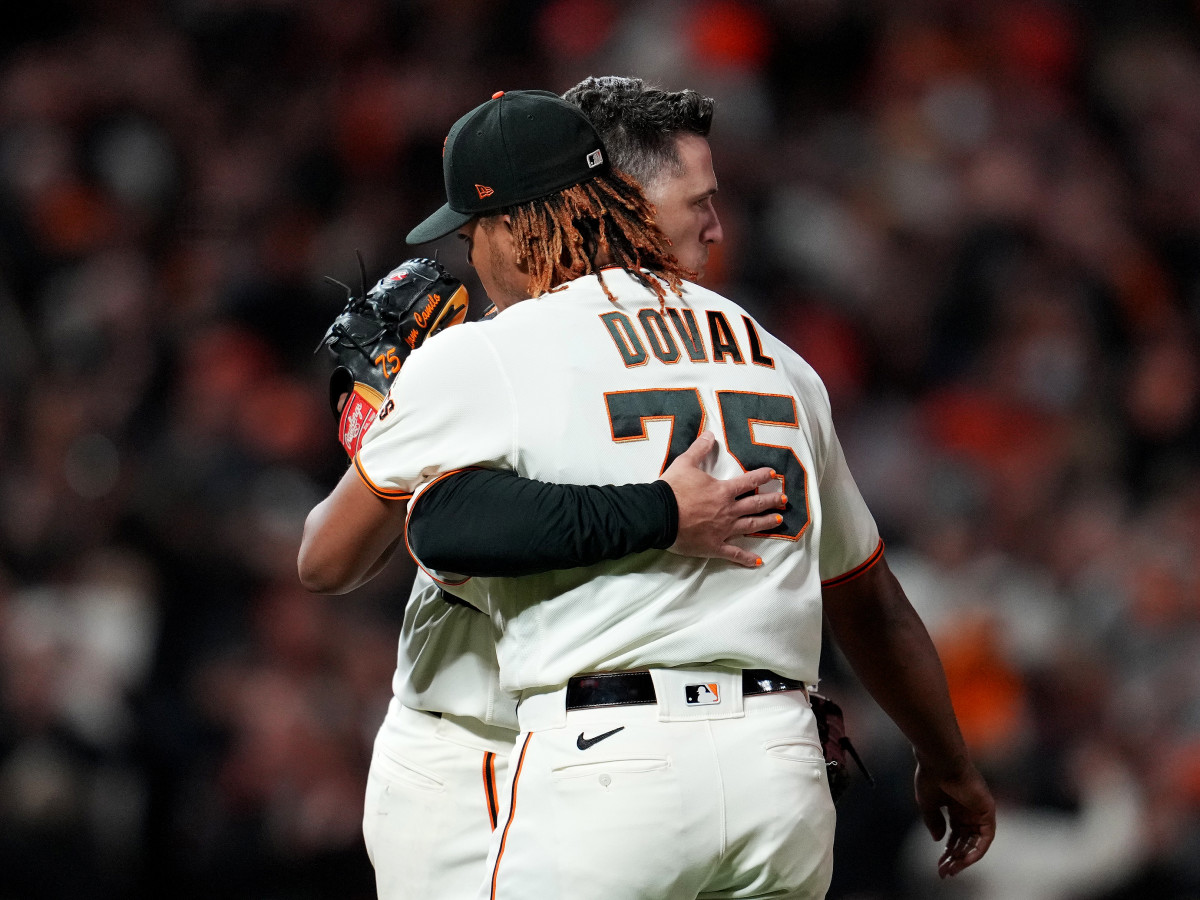 Oct 8, 2021; San Francisco, California, USA; San Francisco Giants catcher Buster Posey (28) hugs relief pitcher Camilo Doval (75) after defeating the Los Angeles Dodgers in game one of the 2021 NLDS at Oracle Park.